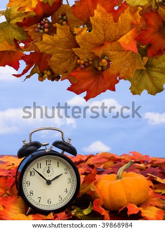 Fall coloured leaves with a black clock on a sky background, Fall Leaves