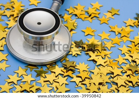 A pile of gold stars and stethoscope on a blue background, excellent healthcare