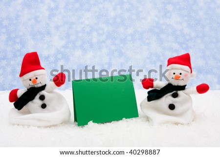 A green blank sign with a snowman sitting on snow background, winter message