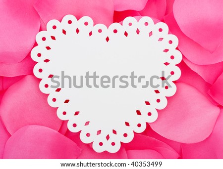 A white heart  cut out sitting on a pink flower petal background, love heart