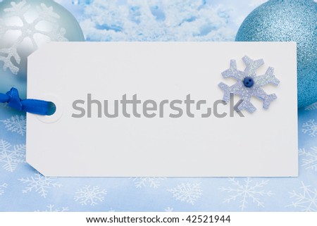 A blank gift tag on a blue snowflake background