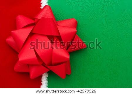 A red plastic ribbon bow on a green background, red bow