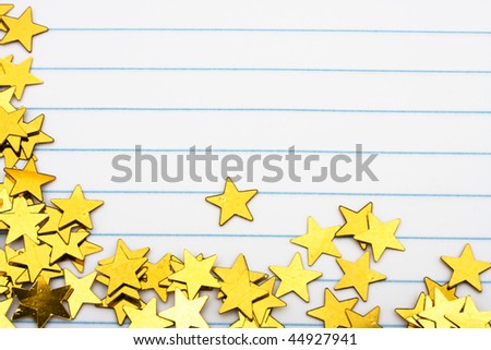 Gold stars making a border on a lined paper background, gold star border