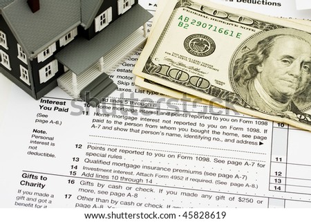 A model house sitting on tax papers, Deduct mortgage interest on taxes