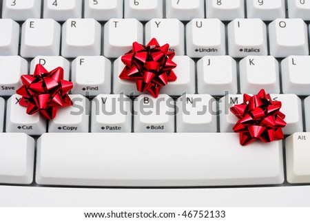 Three red ribbon bows on a computer keyboard, online shopping