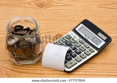 A jar full of change sitting on a wooden background, Calculating your expenses
