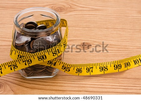 A jar full of change sitting on a wooden background, Calculating your savings