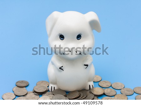 A piggy bank with coins on a blue background, Saving your change