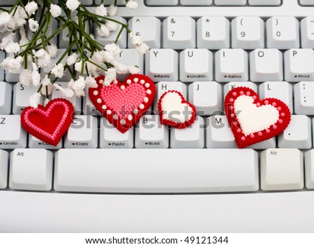 Red hearts sitting on a computer keyboard, internet dating