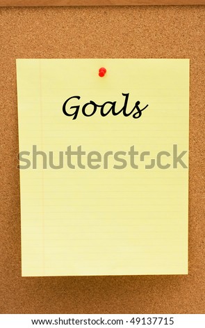 A note on yellow lined paper tacked to a corkboard, Making your goals