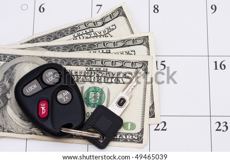 A set of car keys with cash on a calendar, Car Payment is due