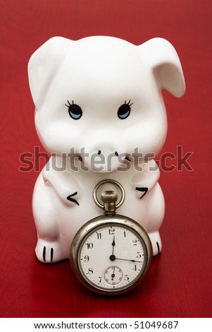 A piggy bank with a retro watch on a red background, saving time