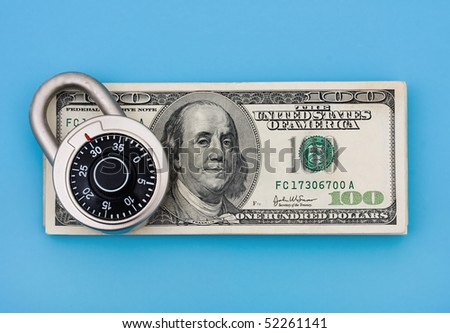 A stack of one hundred dollar bills with a combination lock on it sitting on a blue background, securing finances