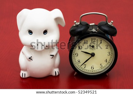 A piggy bank with a retro clock on a red background, saving time