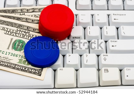 Poker chips and cash sitting on a computer keyboard, Playing poker online