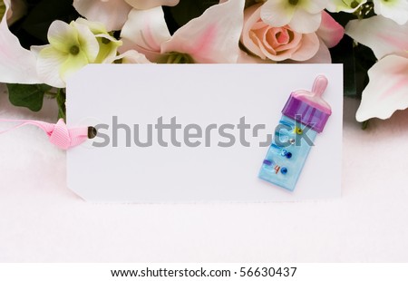 Baby present gift tag with a baby bottle and flowers in background, Welcoming a new baby