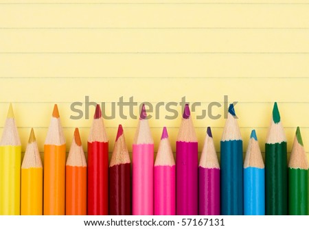 Colorful pencil crayons on a sheet of lined paper, Education background