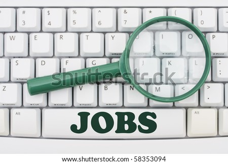 A green magnify glass on a computer keyboard, Job Searching