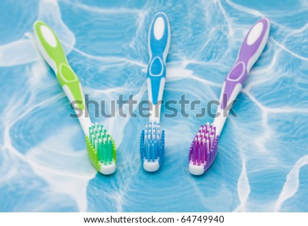 Three toothbrushes on a blue background, toothbrushes