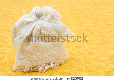 A hand made angel on a yellow background, old fashion angel