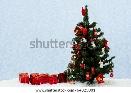 Three red Christmas presents under tree on snow background, Christmas tree