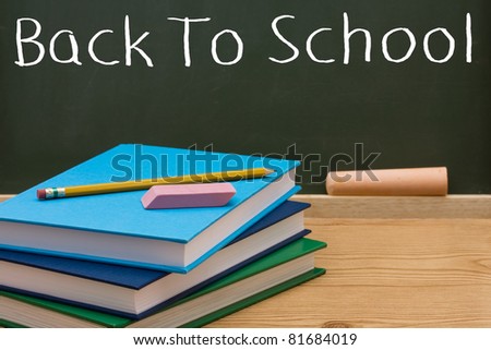 Books with a pencil and eraser in front of a chalkboard, Back to School