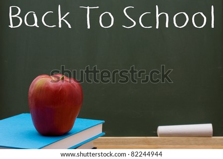 Book with an apple in front of a chalkboard, Back to School