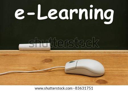 Computer mouse on a desk in front of a chalkboard with copy space, E-learning