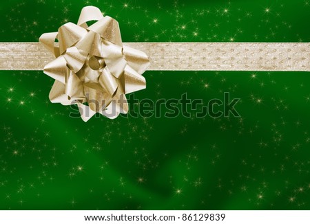 A green Christmas present with a gold bow and ribbon, merry Christmas