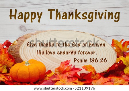 Happy Thanksgiving message, Some fall leaves, an alarm clock and wood plaque on weathered wood with text Psalm 136