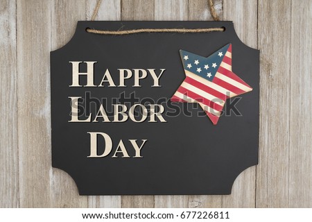 Happy Labor Day text on hanging chalkboard with a flag star on weathered wood wall
