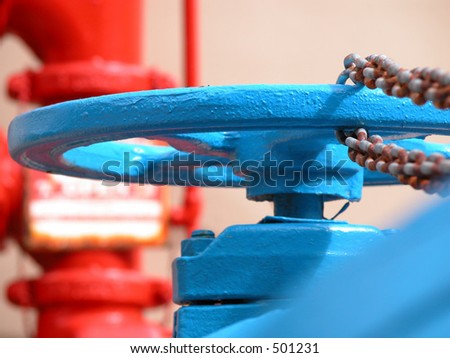 A blue water hydrant with a rusted chain and a red meter in the background.
