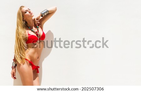 Sexy young blondie woman her hair blowing in the wind posing in  bikini