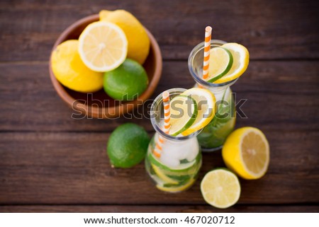 Lemonade drink. Lemonade in the jug and lemons with mint on the table outdoor