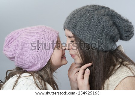 Young girl and baby nose to nose.