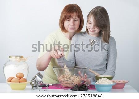 Mom teaches daughter to cook the dough.