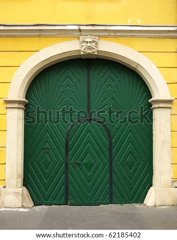 Green painted wooden door with yellow wall