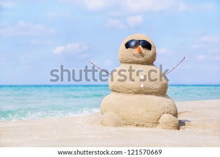 Smiling sandy happy man in sunglasses on the sea beach against blue cloudy summer sky - travel concept
