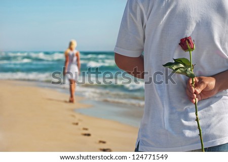 loving couple, man with rose waiting his woman on the sea beach at summer, the romantic, wedding or valentines day concept