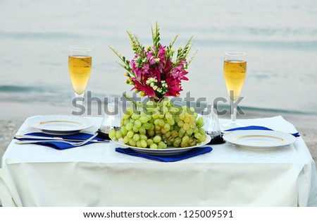 romantic dinner on the sea beach with candles and wine
