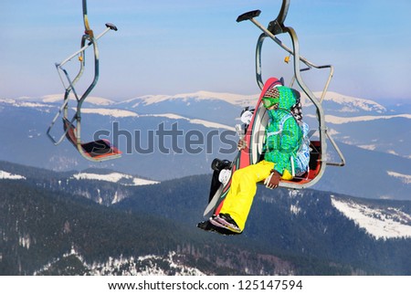 Snowboarders couple on a ski lift