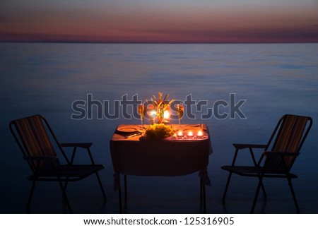 romantic dinner on the sea beach with candles and wine