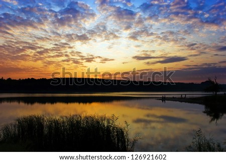 bright cloudy sunset above the lake