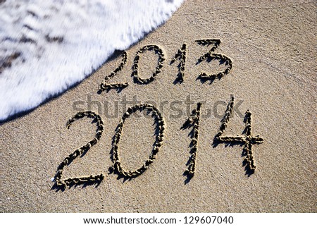 Happy New Year 2014 replace 2013 concept on the sea beach