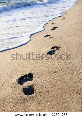 sand beach, wave and footsteps at sunset time
