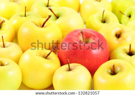 red apple between yellow apples as distinguished concept