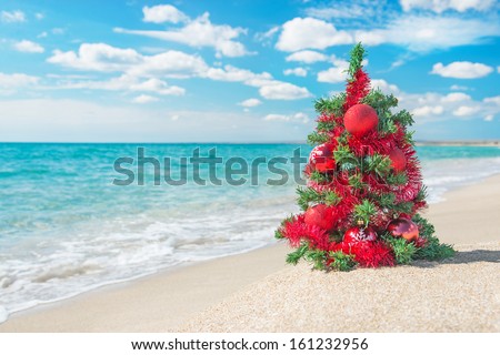 Christmas Tree With Red Decorations On The Sea Beach. Christmas Vacation Concept.