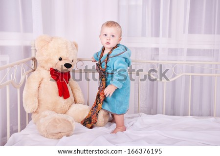 year-old child portrait in men\'s tie and toy bear in home interior