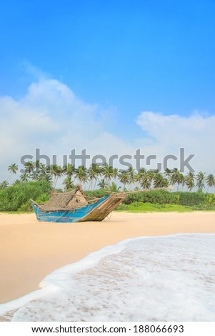 Fishing boat at beautiful sandy ocean palm beach, Indian Ocean