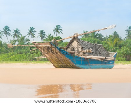Fishing boat at beautiful sandy ocean palm beach, Indian Ocean